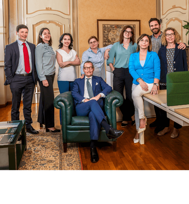 Foto dello staff di sirt nella propria sede a tortona, il titolare è seduto su una poltrona in pelle color verde scuro